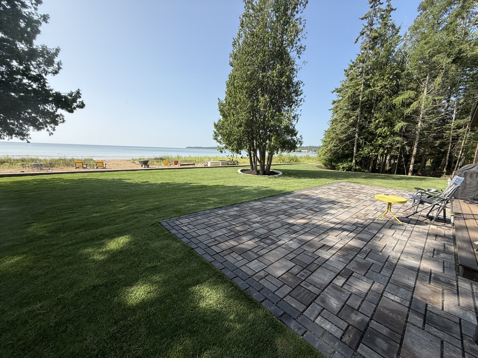 Lakeside lawn and paver patio at a Door County home