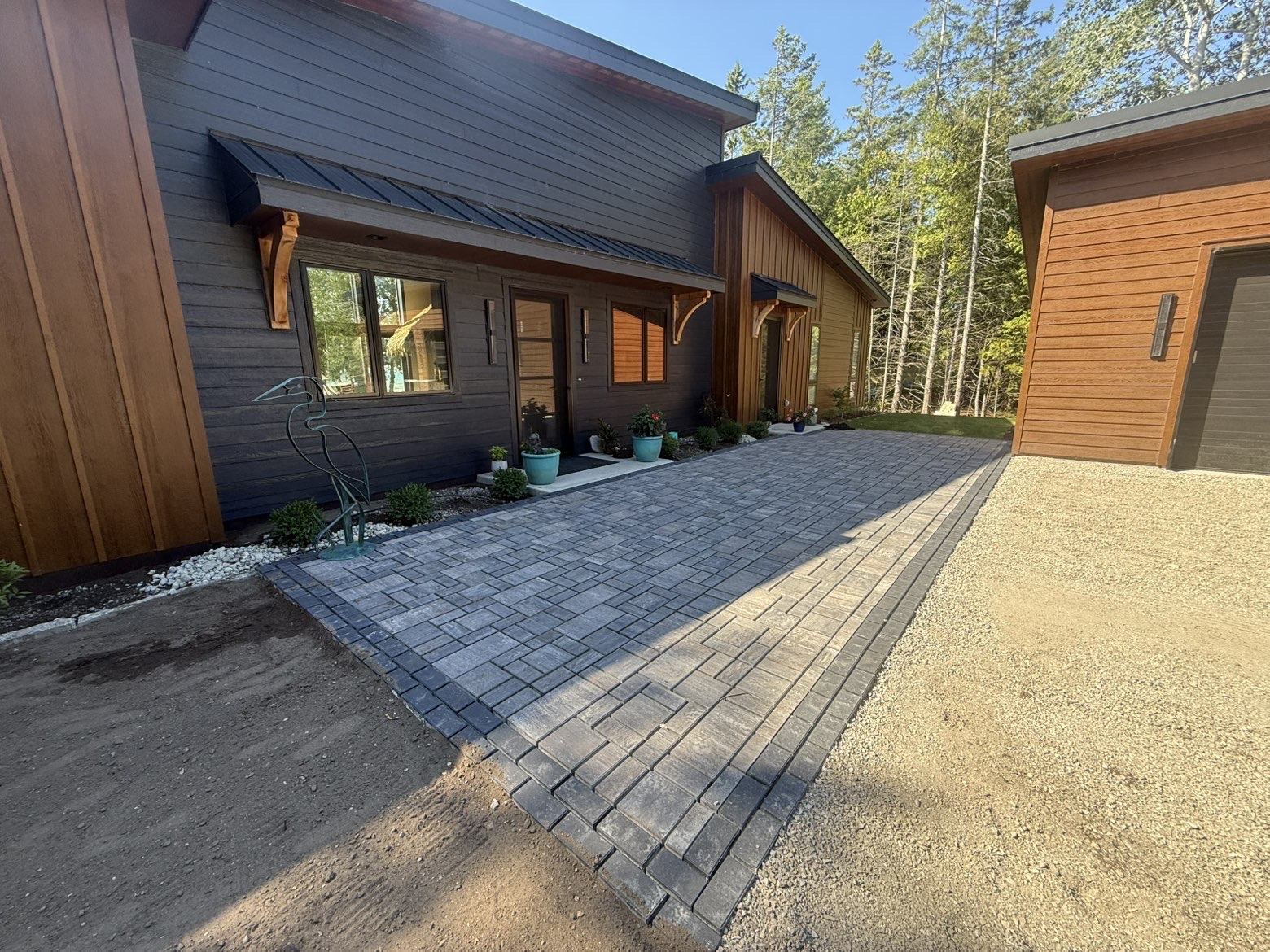 Finished paver courtyard connecting a Door County home and garage