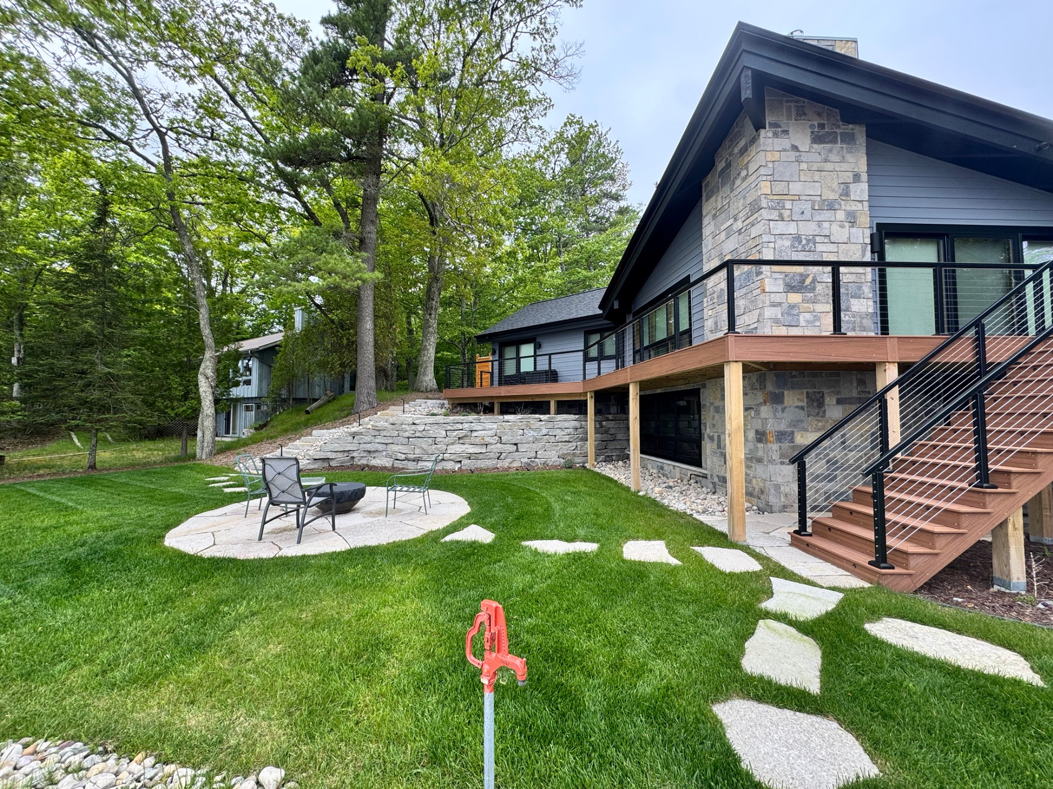 Finished backyard lawn with flagstone seating area and retaining wall