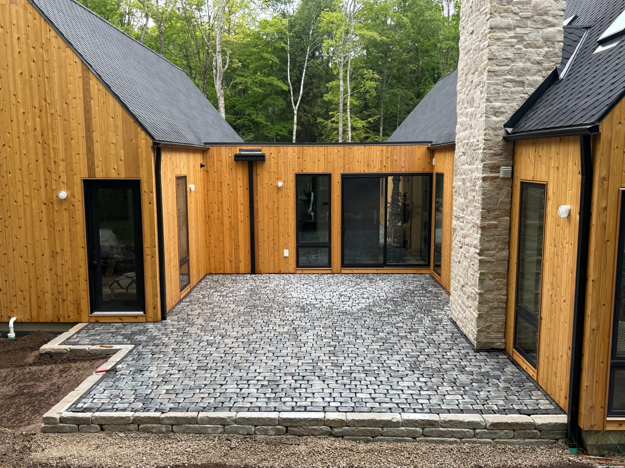 Stone paver courtyard between modern wood buildings