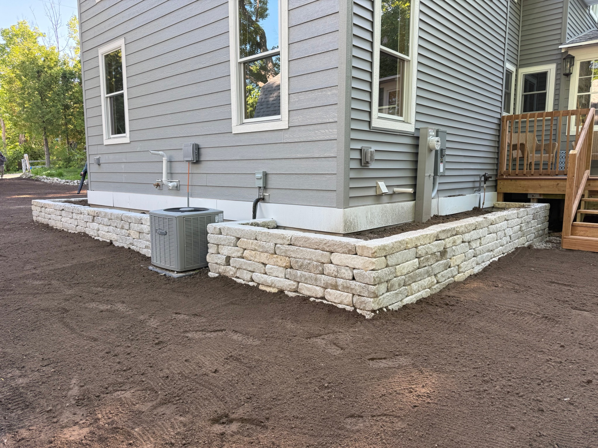Natural stone retaining wall beside a home